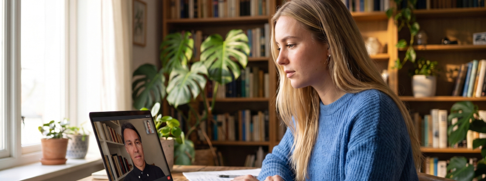 Mulher em sessão de psicoterapia on-line por tablet, em casa, com a luz natural da janela